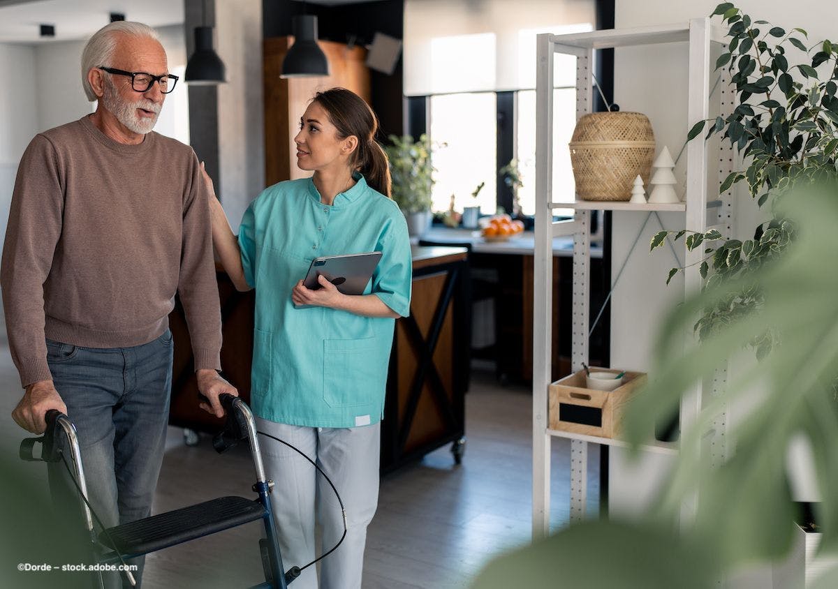 A nurse helps a patient who uses a walker and glasses. Image credit: ©Dorde – stock.adobe.com