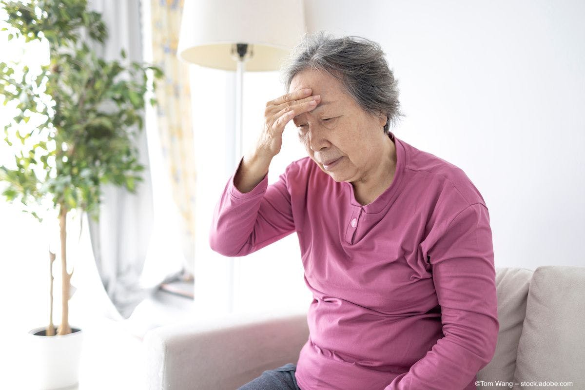 An elderly woman clutches her forehead in pain. Image credit: ©Tom Wang – stock.adobe.com