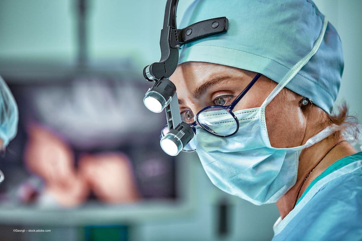 An eye surgeon with glasses stands masked in the operating theater. Image credit: ©Georgii – stock.adobe.com