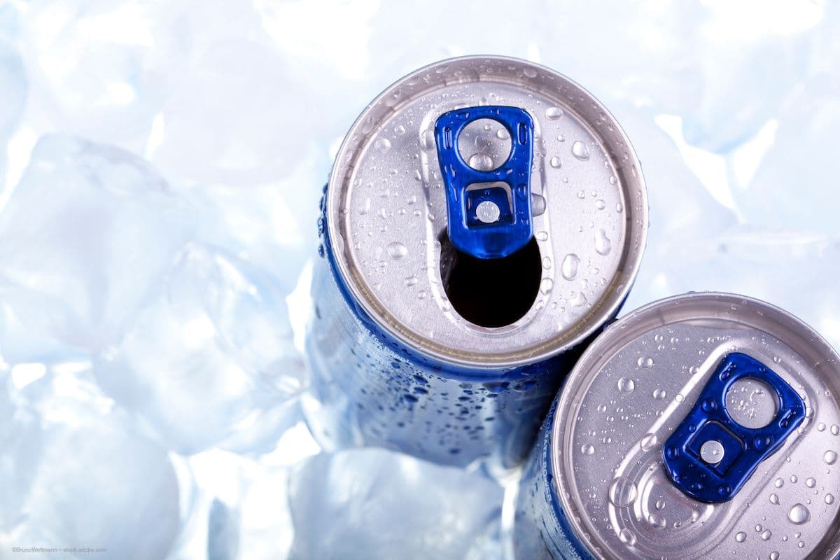 The tops of two energy drink cans. The cans are in a bath of ice cubes. Image credit: ©BrunoWeltmann – stock.adobe.com