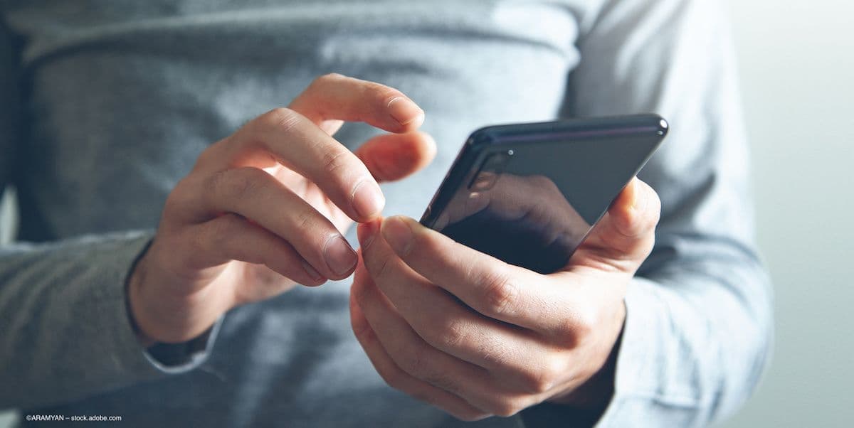 A person holding a cell phone. Image credit: ©ARAMYAN – stock.adobe.com