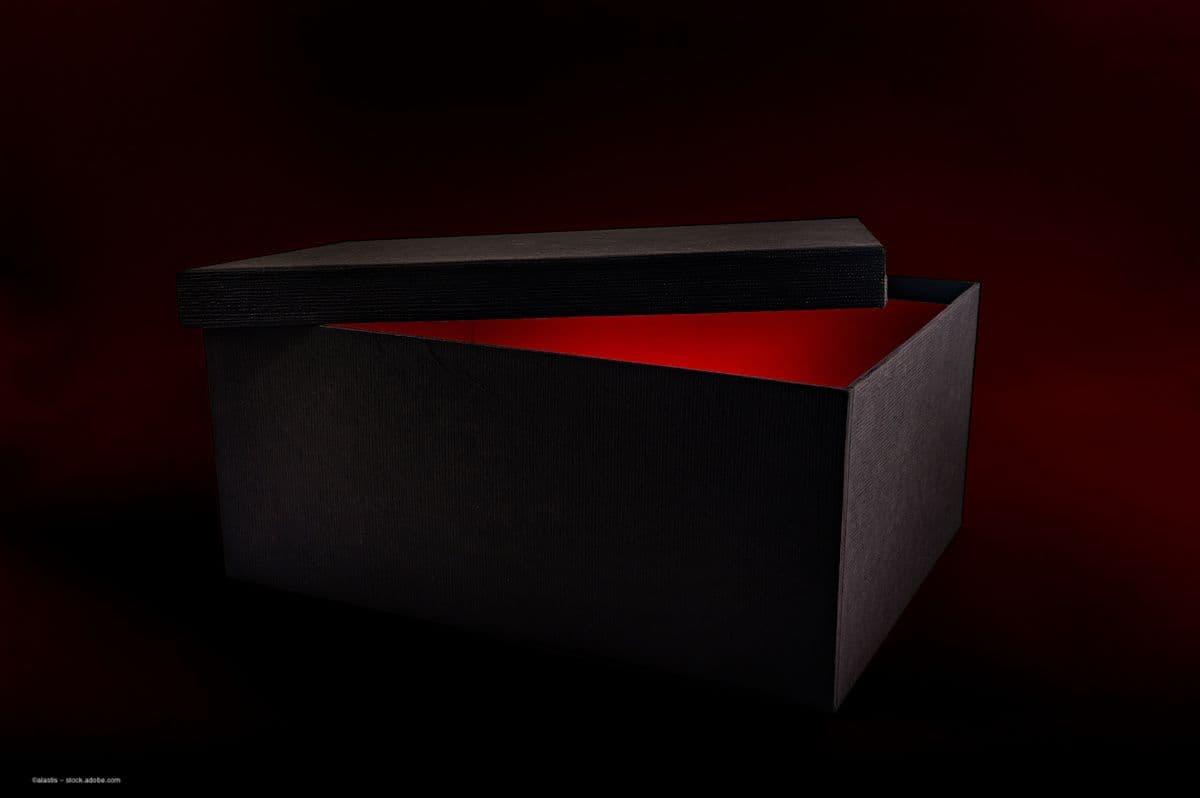 A black box in a dark room is opened slightly. The lid is displaced and a red light glows inside. Image credit: ©alastis – stock.adobe.com