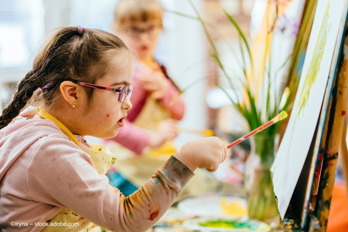 A child with glasses paints at an easel. Image credit: ©Iryna – stock.adobe.com