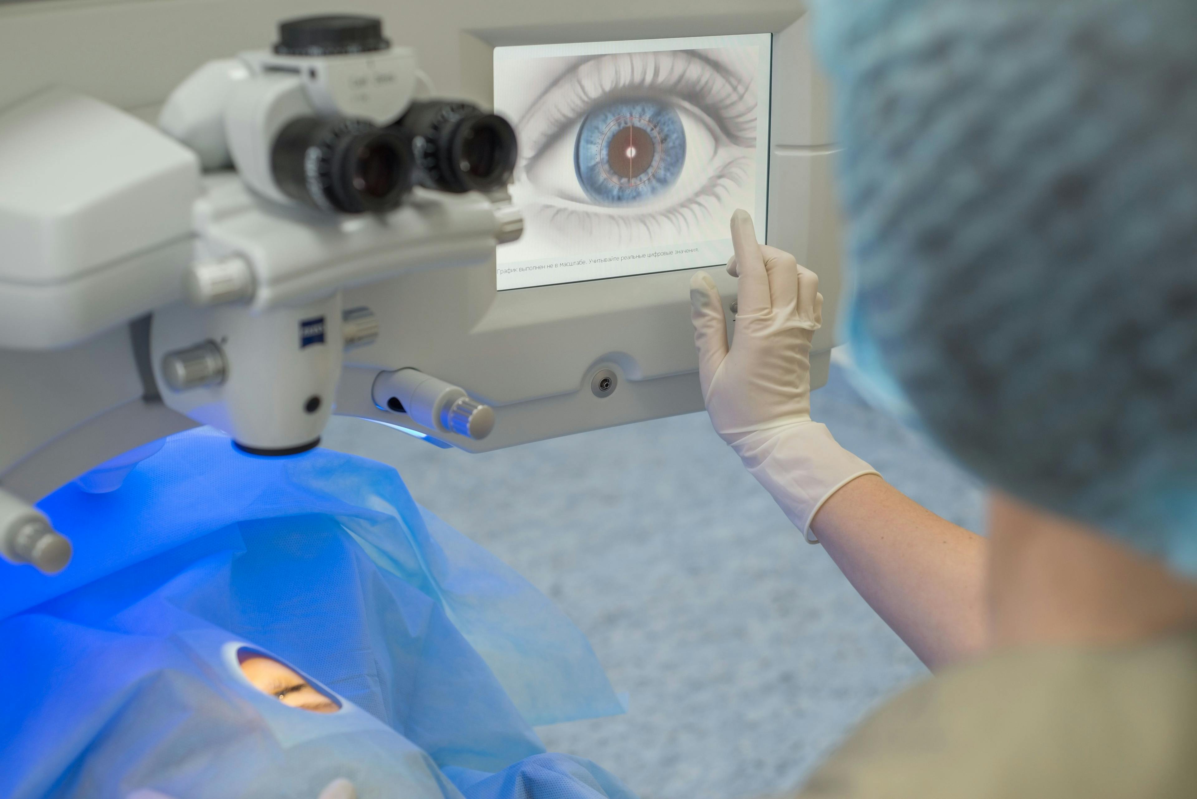 Ophthalmologist setting up monitor for use in laser surgery of eye