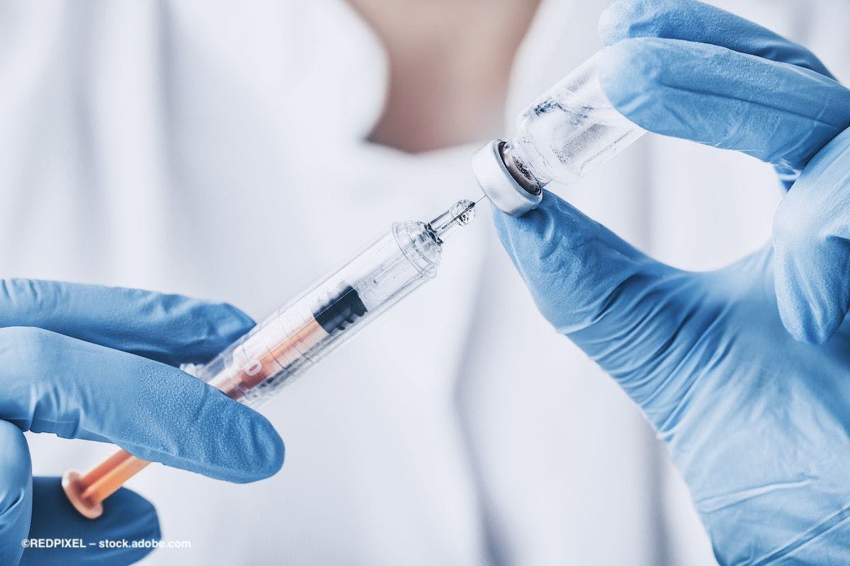 A syringe and small bottle of injectable medication, being held by gloved hands. Image credit: ©REDPIXEL – stock.adobe.com