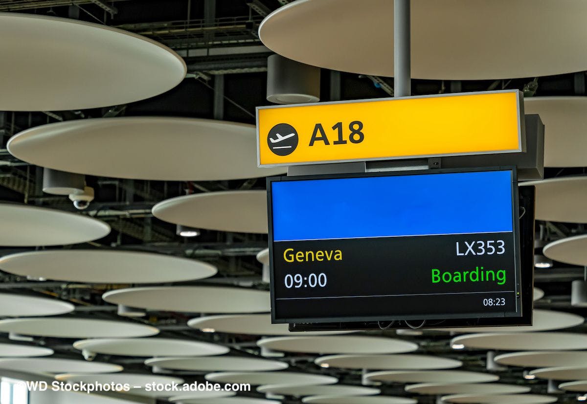 An airport departure board shows a flight to Geneva is boarding. Image credit: ©WD Stockphotos – stock.adobe.com