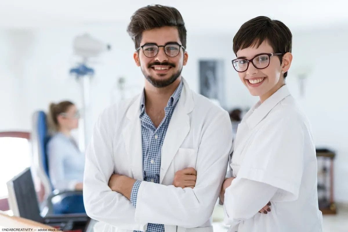 Two smiling young physicians in a clinical setting. Image credit: ©NDABCREATIVITY – stock.adobe.com