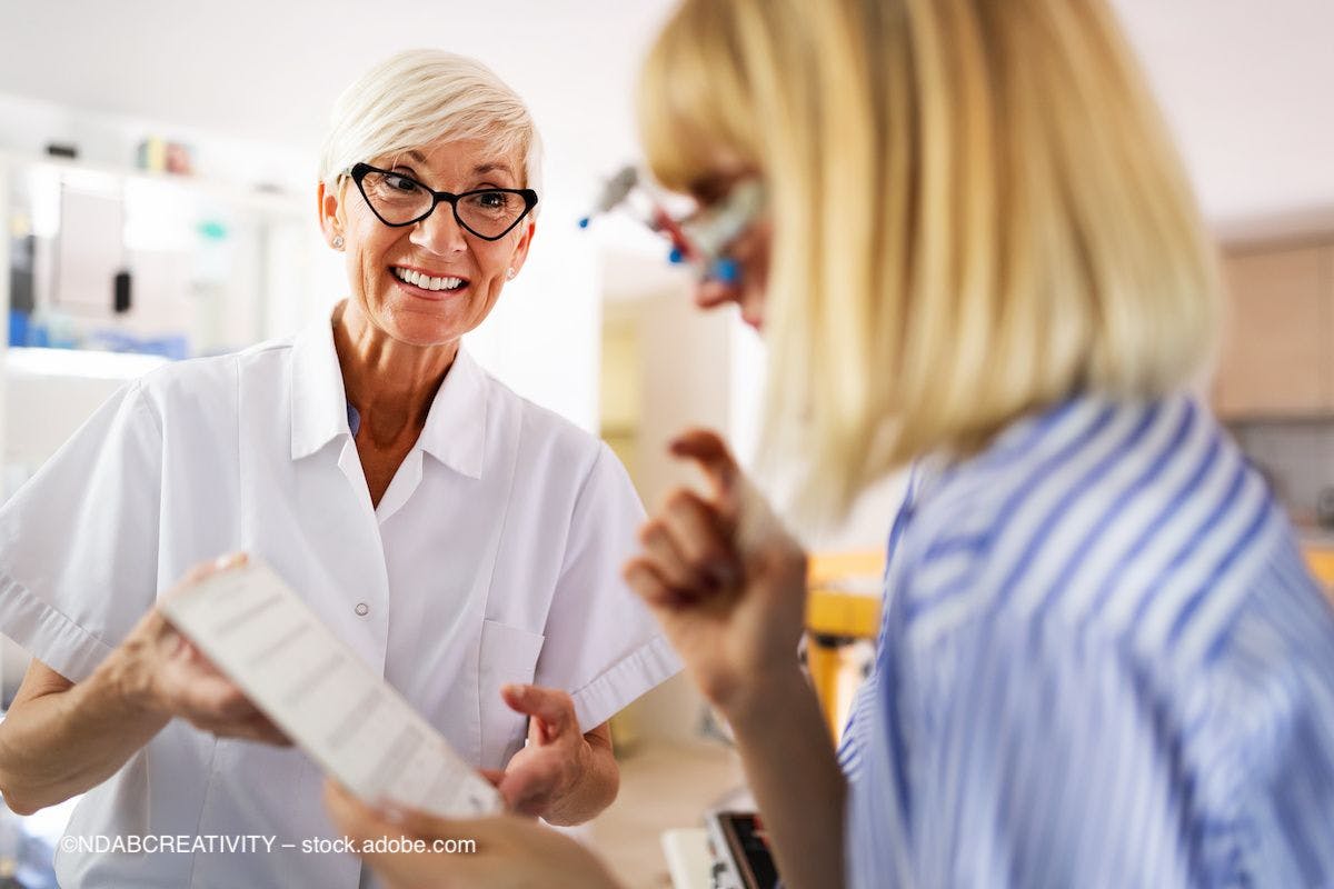 An optometrist helps a patient understand her chart. Image credit: ©NDABCREATIVITY – stock.adobe.com