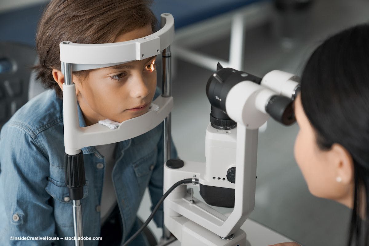 A child situates his head in a slit lamp for eye examination. Image credit: InsideCreativeHouse – stock.adobe.com